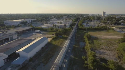 Aerial Reveal of Train going through Industrial Town Stock Footage 67561016