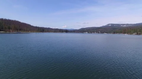 Aerial Reverse Ascend Over Blue Lake with Boats and Mountains Vídeos de archivo 77192426