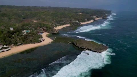 Aerial reverse dolly view of a beautiful beach of Central Java - Slili Stock Footage 283352644