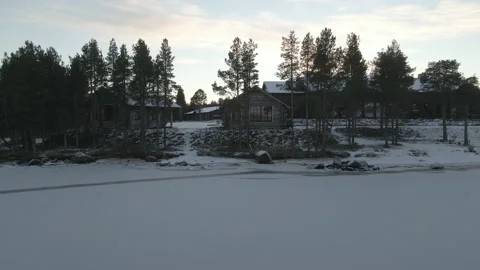 Aerial Reverse Drone Flight Of Cabine At Frozen Lake Inari At Wilderness Hotel Stock Footage 224305230