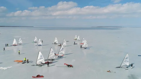 Aerial reverse passing of ice yachts on frozen sea ice in Estonia Stock Footage 88201070