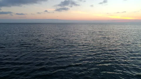 Aerial Reverse Pullback Shot of a Calm Ocean at Sunset Stock Footage 136475476