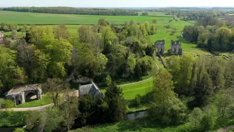 Aerial reverse reveal shot pulling back from ruined stone chancel to showcase Vídeo Stock 348232931