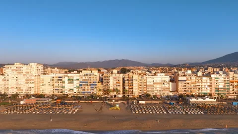 Aerial reverses from array of medium rise hotels and apartments at golden Vidéo 317446270