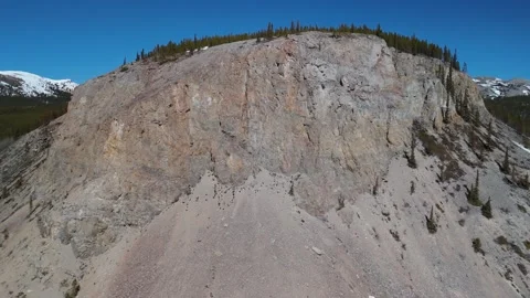 Aerial right to left of a rock faced mountain Stock Footage 308668280