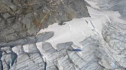 Aerial Right/Pan Up of Shadow Of Helicopter On Bumpy, Snowy Valley At Bottom Of Stock Footage 113948103