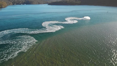 Aerial Rises as Jet Ski Does Donuts in River. Wide Shot Stockbeeldmateriaal 129790838