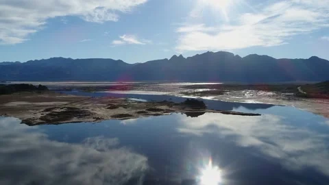 Aerial rises over near empty water reservoir in sunny summer drought Stock Footage 330862700