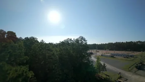 Aerial rising over pine forest revealing rural industrial compound Stock Footage 346624094