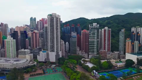 Aerial rising pull back over dense residential skyscrapers Victoria Park sports Stock Footage 336341545