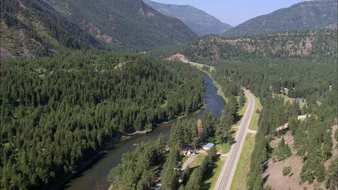Aerial of river flowing through forest trees, Road following river in mountains Stock Footage 109469296