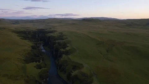 Aerial of river flowing through green mountains during sunset Stock Footage 74907985