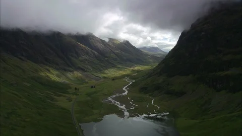 Aerial of river flowing through the mountain ranges, Glencoe And Mountains Stock Footage