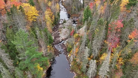 Aerial River Running Through Rocks Reflecting Cloudy Skies and Autumn Colors Stock Footage 315265864