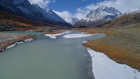 Aerial. River running through snowy mountains valley Stock Footage 81499786