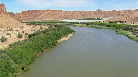 Aerial of river stream flowing through lush green plants, Low Up River Orange Ff Stock Footage 109446184