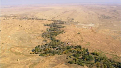 Aerial of river stream surrounded with trees flowing near mountain base, Green Stock Footage 109471096