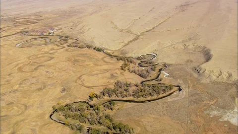 Aerial of river stream surrounded with trees flowing near mountain base, Green Stock Footage 109471136