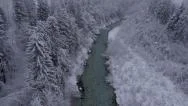 Aerial - River Through The Winter Forest At A Light Snowing Stock Footage