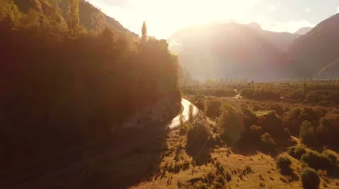 Aerial: Road going through mountain valley golden sunrise slow tracking 2K Stock Footage 64670369