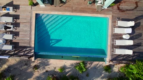 Aerial rocket overhead shot of infinity pool, pool deck and chairs at Caribbean Stock Footage 334818259