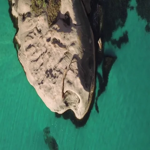 Aerial of a rocks in between beautiful turquoise sea Stock Footage 69492633