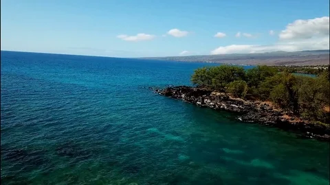 Aerial rocky ocean point and beach (Waialea Beach) Stock Footage