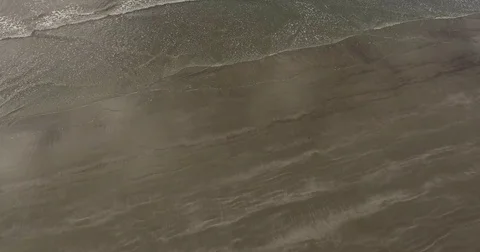 Aerial of rolling waves on a dark sandy beach Stock Footage 76676666