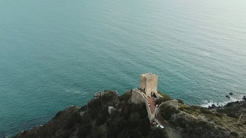 Aerial romantic view of a sunset over the sea with medieval tower in foreground Stock Footage 104490260