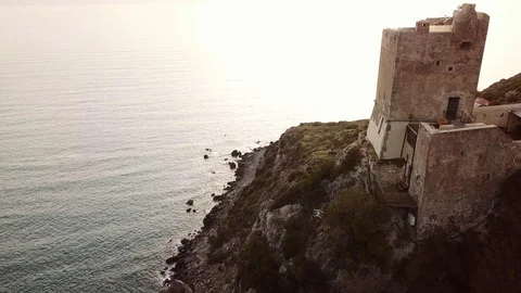 Aerial romantic view of a sunset over the sea with medieval tower in foreground Stock Footage 104490610