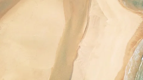 Aerial rotating top-down view over a river forming a beach lagoon Vídeos de archivo 127993816