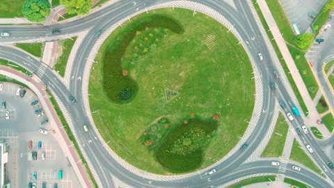 Aerial rotating top-down view of a roundabout or traffic circle in a summer city Stock Footage 282546822