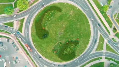 Aerial rotating top-down view of a roundabout or traffic circle in a summer city Stockbeeldmateriaal 300923275