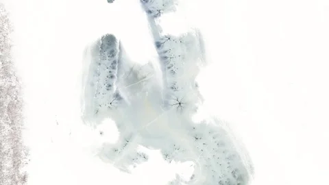 Aerial rotating top-down winter view of frozen lake, ice texture with cracks. Video stock 251692070