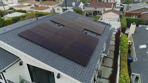 Aerial rotating view of completed solar panel array installation on house Stock Footage 169271415
