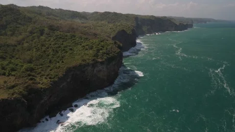 Aerial rotating view of massive cliffs jutting down into the sea. Stock Footage 293714698