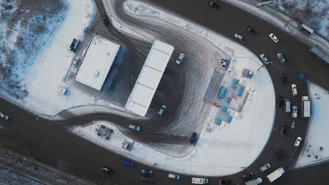 Aerial rotational view traffic on circle road with gas station in winter city. Stock Footage 104574440