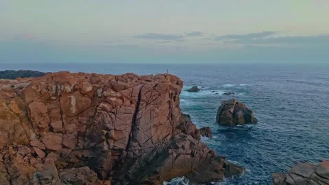 Aerial rugged rocky cliffs along a dramatic coastline with ocean waves Stock Footage 340076632