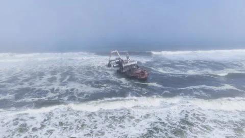 Aerial of rusting shipwreck with A frame crane on Namibia Skeleton Coast Stockbeeldmateriaal 341423928