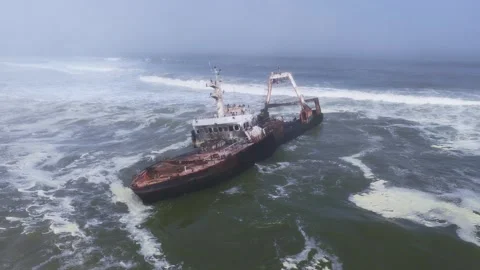 Aerial rusting shipwreck in surf on Namibia Skeleton Coast, Atlantic Stock Footage 341424072