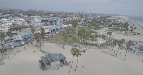 Aerial sailing over the people enjoying themselves on the Venice Beach boardwalk Stock Footage