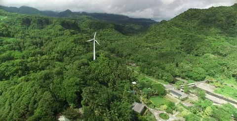 Aerial sailing past windmill towards the lush green Dominican landscape 스톡 동영상 69985751