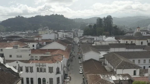 Aerial sails low over a main street in Popayan, Colombia past the main plaza Stock-Footage 105360970
