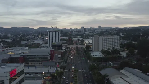 Aerial sails low over main street of San Salvador, El Salvador at dusk Stock-Footage 168283640