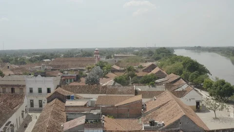 Aerial sails low over rooftops towards the San Francisco church in Mompox Stock Footage 108637176