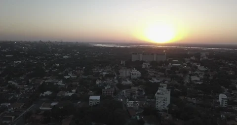 Aerial sails over the rooftops of Asuncion, Paraguay towards river at sunset Stock-Footage 92449752