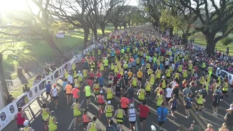 Aerial scene with drones. Aerial camera travels forward of marathon by avenue. Stock Footage 156987700