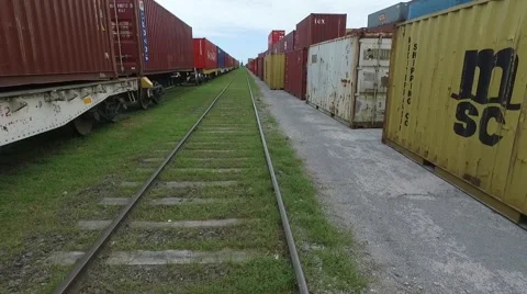 Aerial scene moving forward through a train rail and flying over containers on a Vídeo Stock 59995488