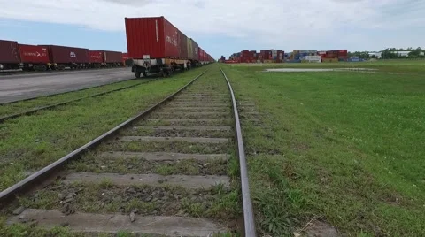 Aerial scene moving forward a train rail and flying over containers on an import Vídeo Stock 59893684