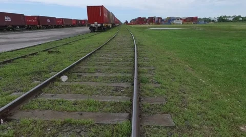 Aerial scene moving forward a train rail and flying over containers on an import Vídeo Stock 59965522